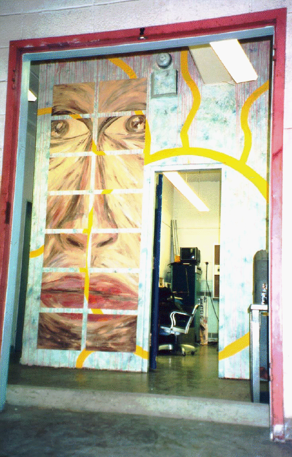 The 1994 ham shack door Door to the painted showing a face and stylized Sun.